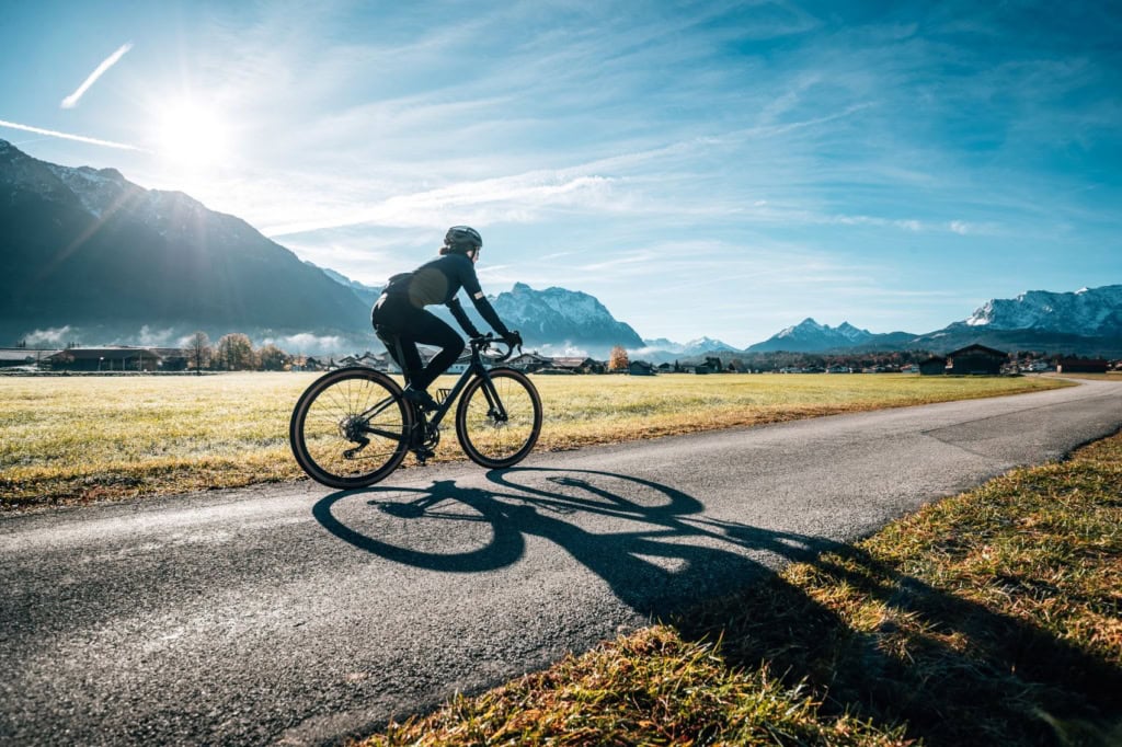 Gravelbiker fährt vor dem Alpenpanorama durch die Zugspitz Region