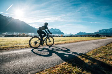 Gravelbiker fährt vor dem Alpenpanorama durch die Zugspitz Region