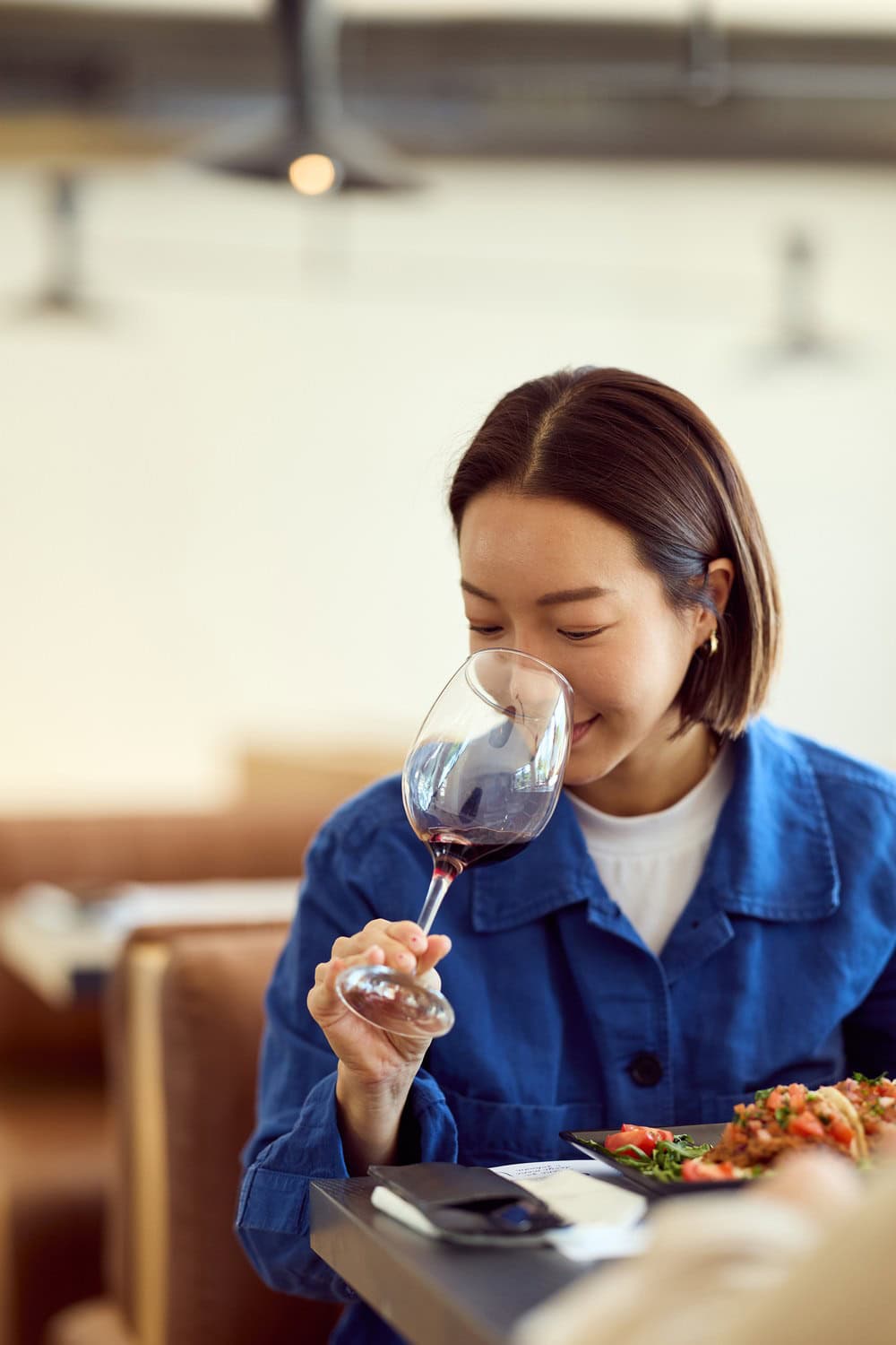 Genussmoment im Restaurant: ein Glas Rotwein und ein frischer Salat. Ist das eine Inspekteurin?Foto: Branislav Nenin / Shutterstock