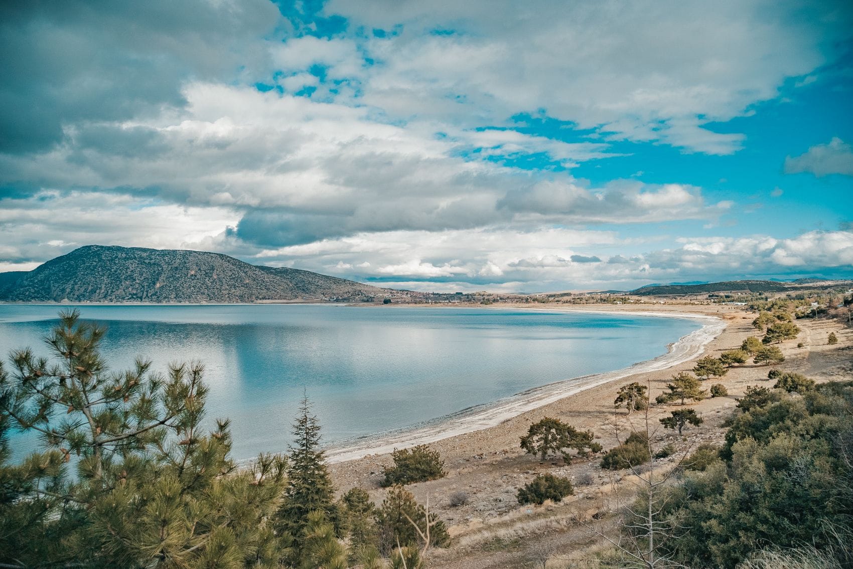 Salda-See bei Burdur mit bewaldetem Ufer und Bergen unter bewölktem Himmel