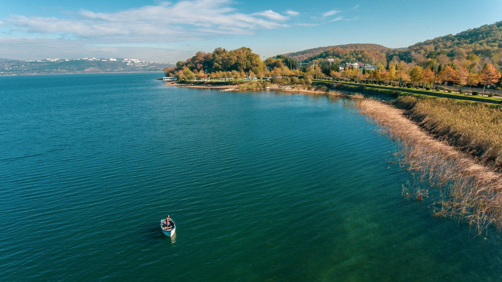 Sapanca-See bei Sakarya mit Boot und herbstlich gefärbten Bäumen am Ufer
