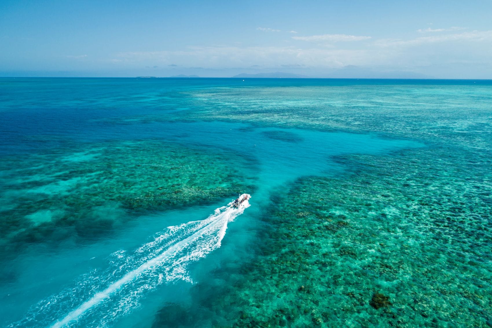 Ausflugsboot fährt über das türkisfarbene Great Barrier Reef vor Cairns in Queensland