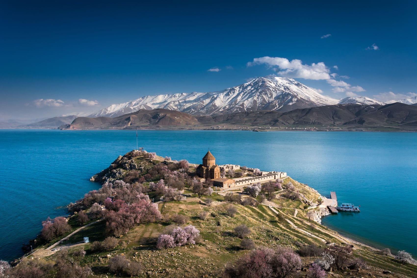 Insel Akdamar mit der Heilig-Kreuz-Kirche im Vansee vor schneebedeckten Bergen in Ostanatolien