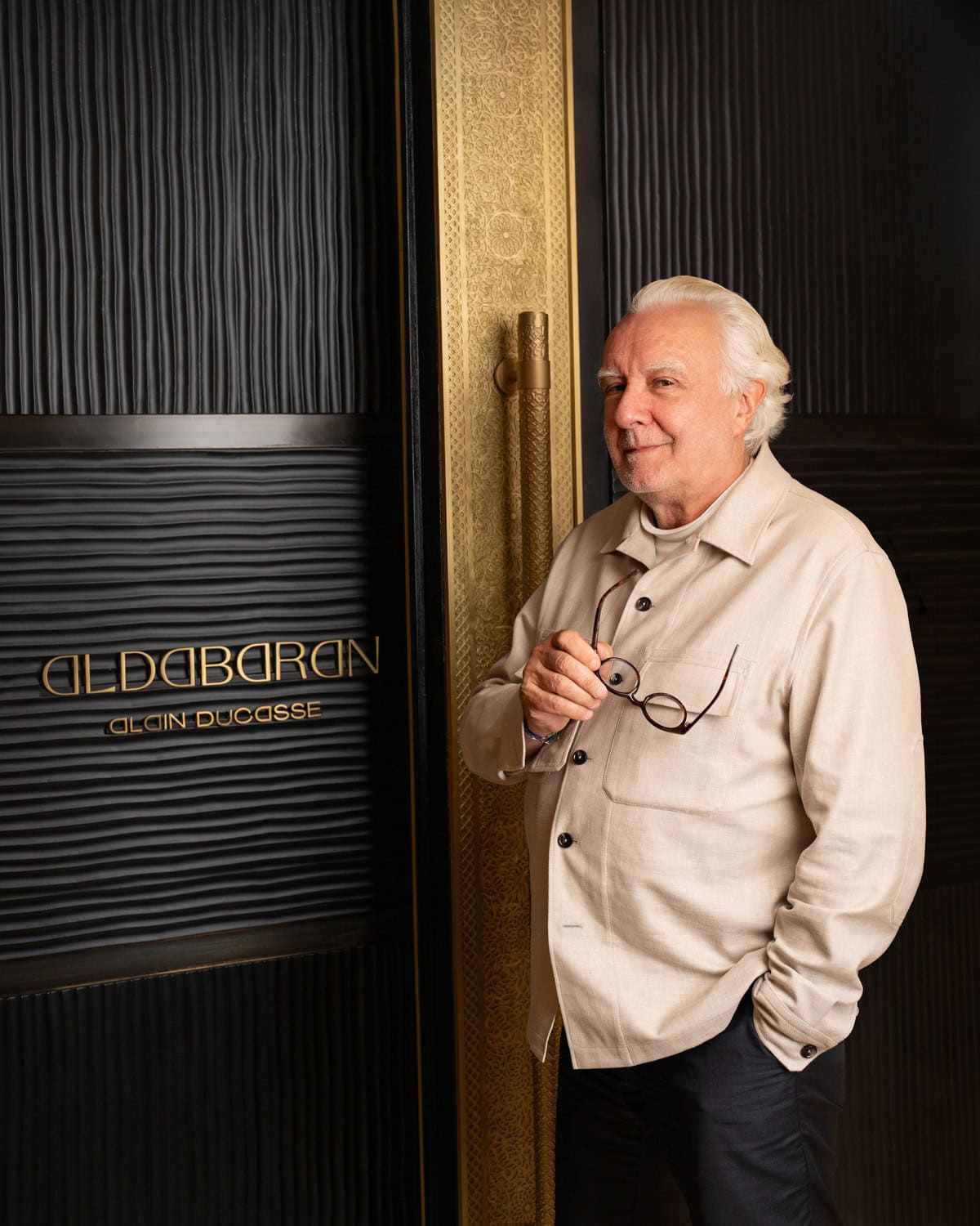 Alain Ducasse im hellen Hemd am Eingang seines Restaurants Aldabaran im Mohammed VI Tower in Rabat