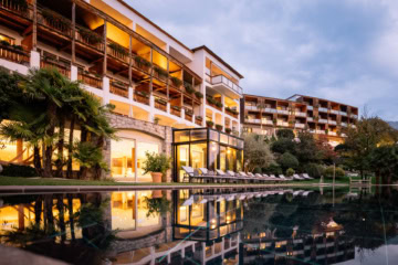Außenansicht des Hotel Hohenwart in Schenna mit Pool und Garten.