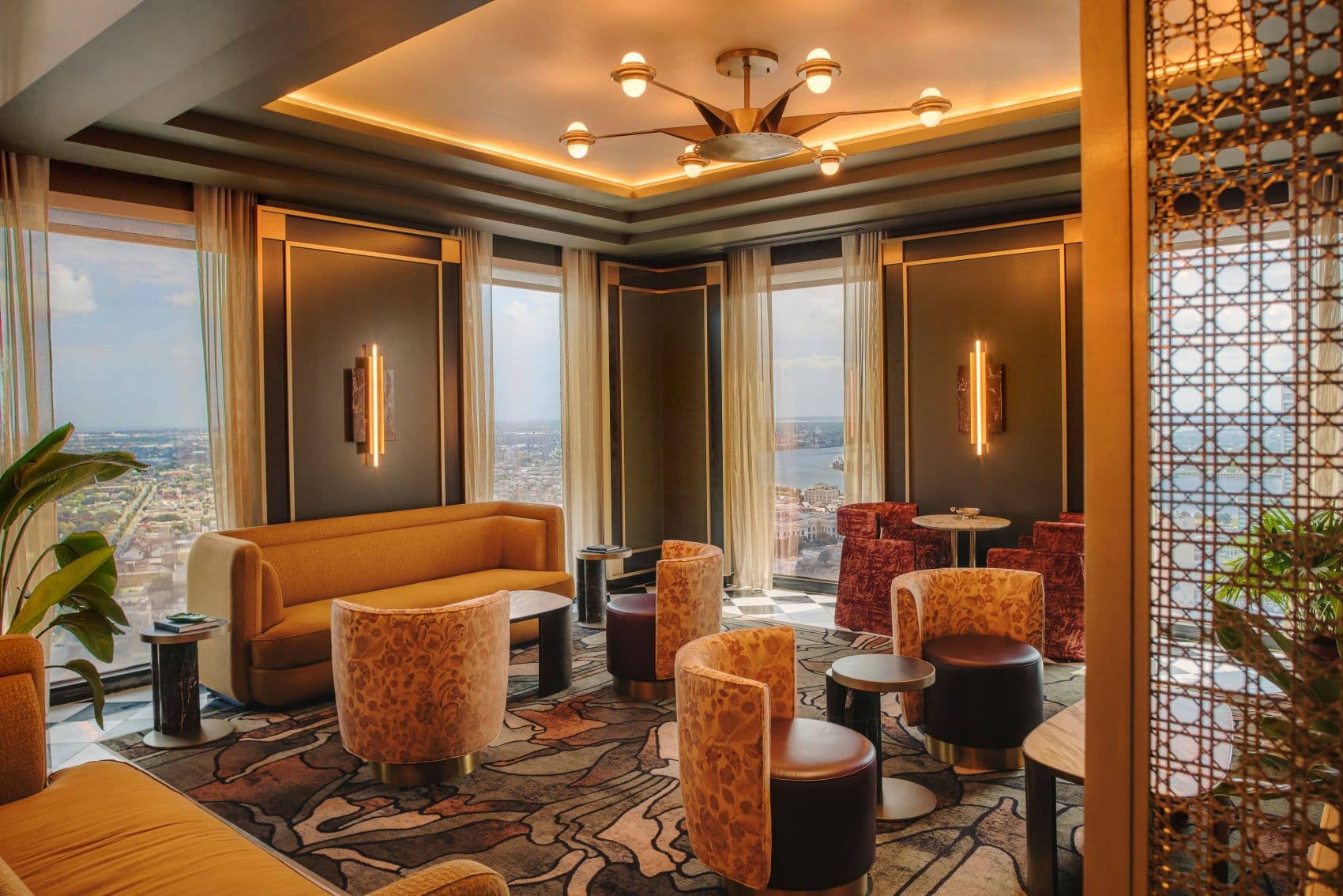 Club Lounge des Fairmont New Orleans mit goldfarbenem Sofa, gemusterten Sesseln und Panoramablick über die Stadt.