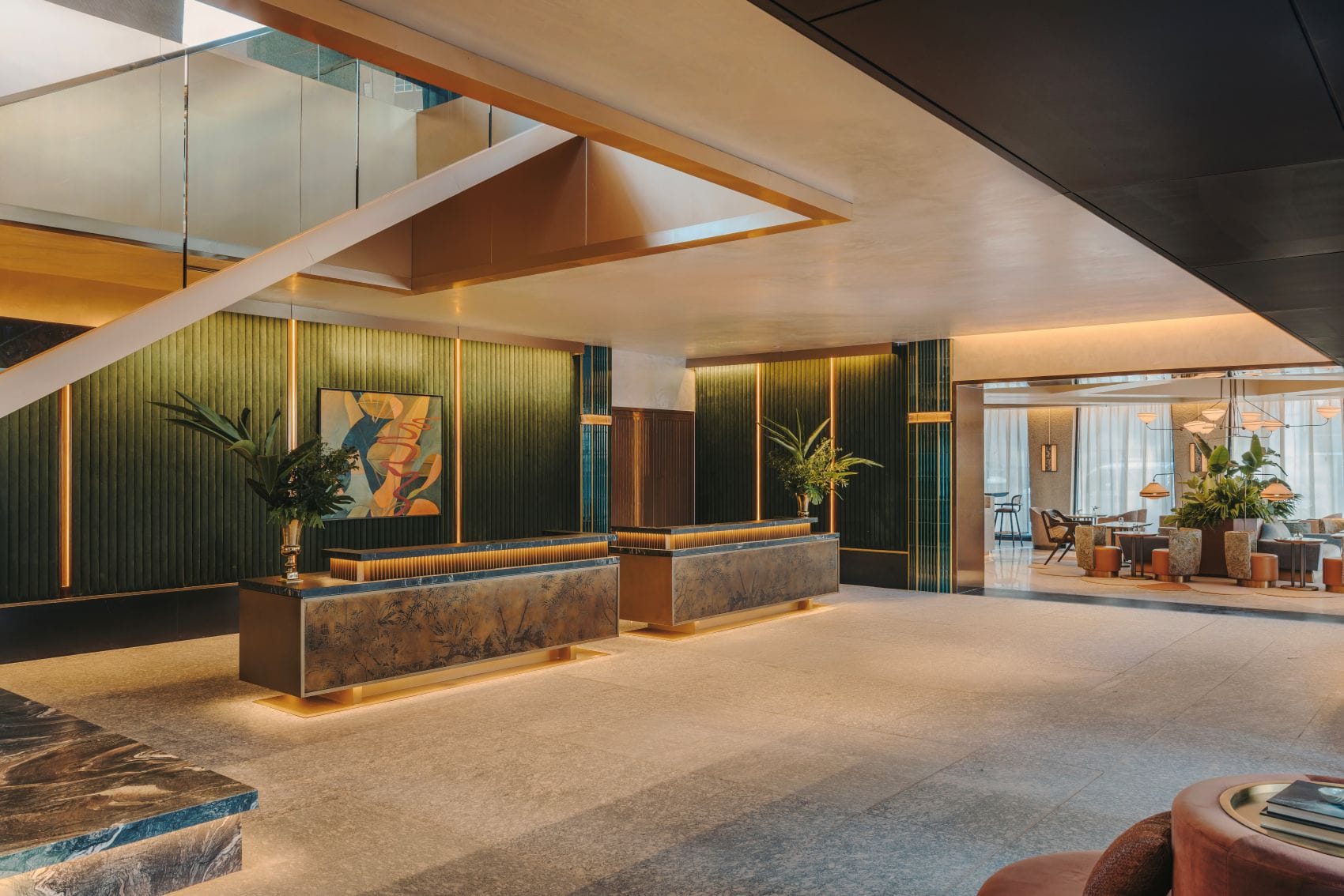 Lobby des Fairmont New Orleans mit zwei Empfangstresen, dunkelgrünen Wandverkleidungen und geometrischer Deckengestaltung.