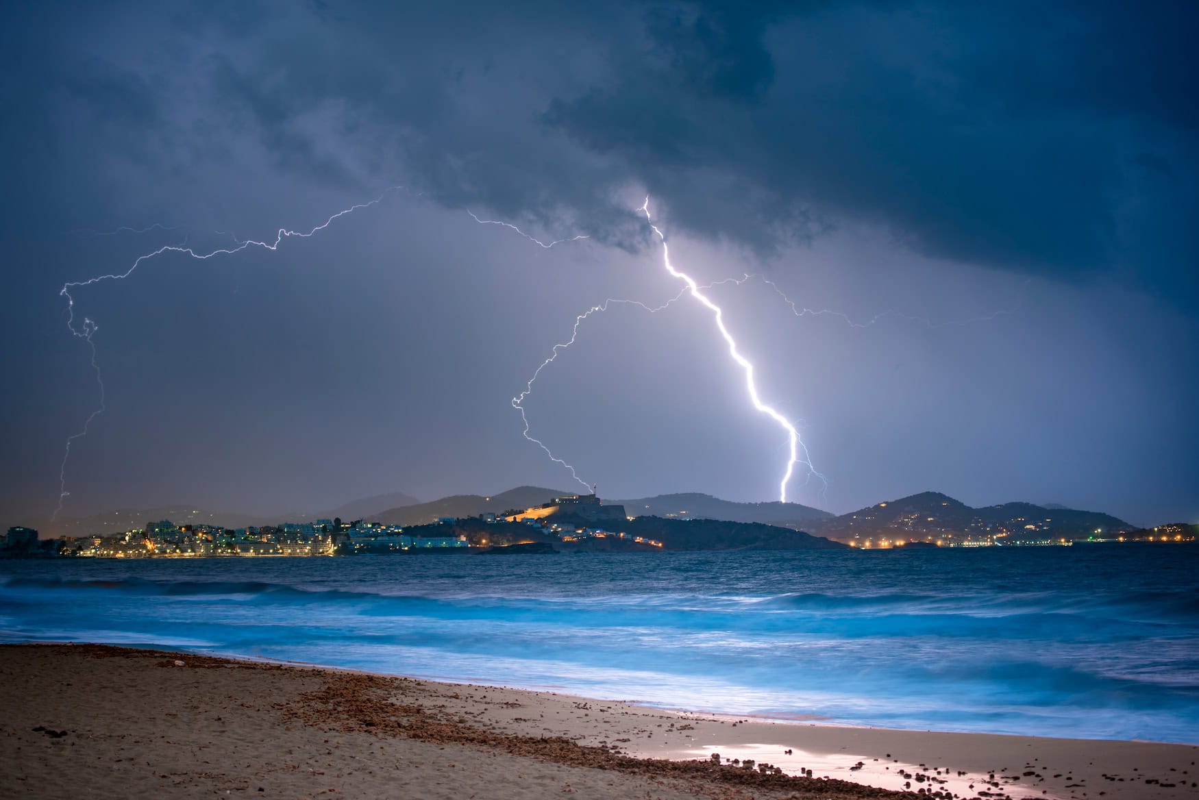 Gewitter mit Blitzen und dunklen Wolken über dem Meer vor Ibiza