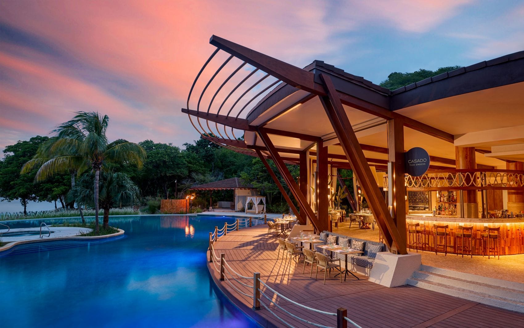 Pool und beleuchtete Restaurantterrasse im JW Marriott Costa Elena in der Abenddämmerung.