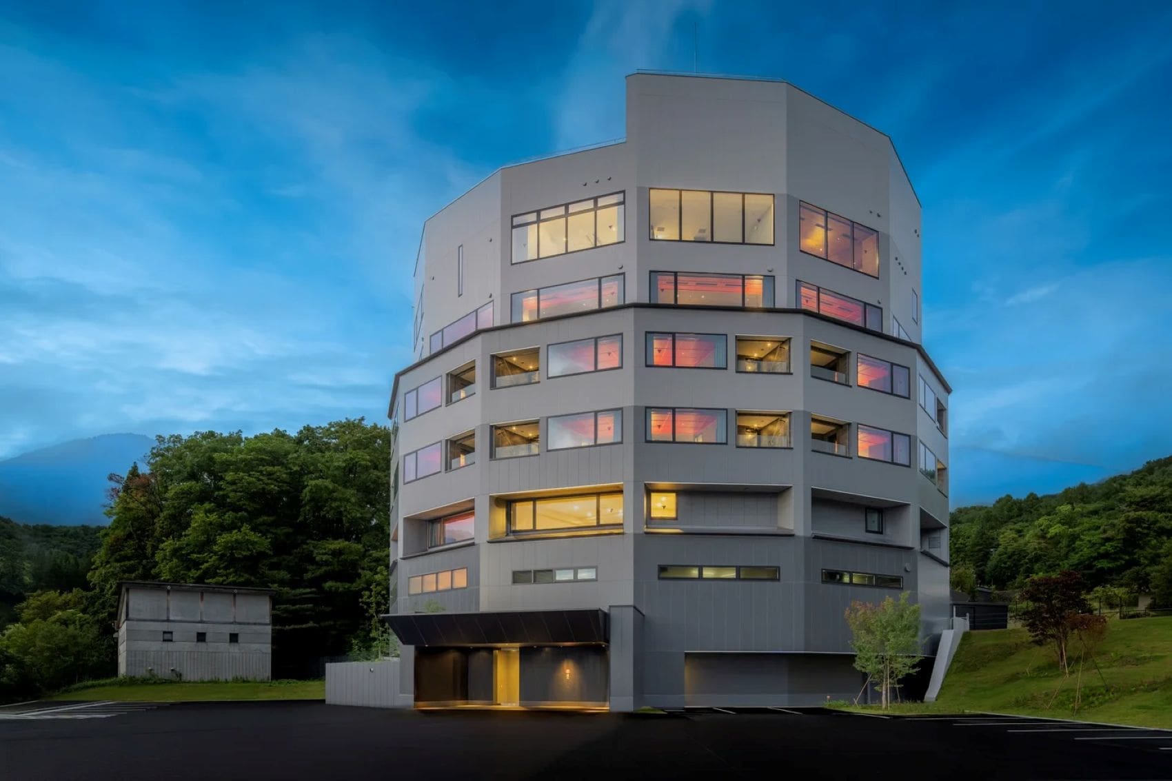 Außenansicht des KAI Zao in Yamagata, Japan, mit seiner markanten, vieleckigen Fassade in der Abenddämmerung