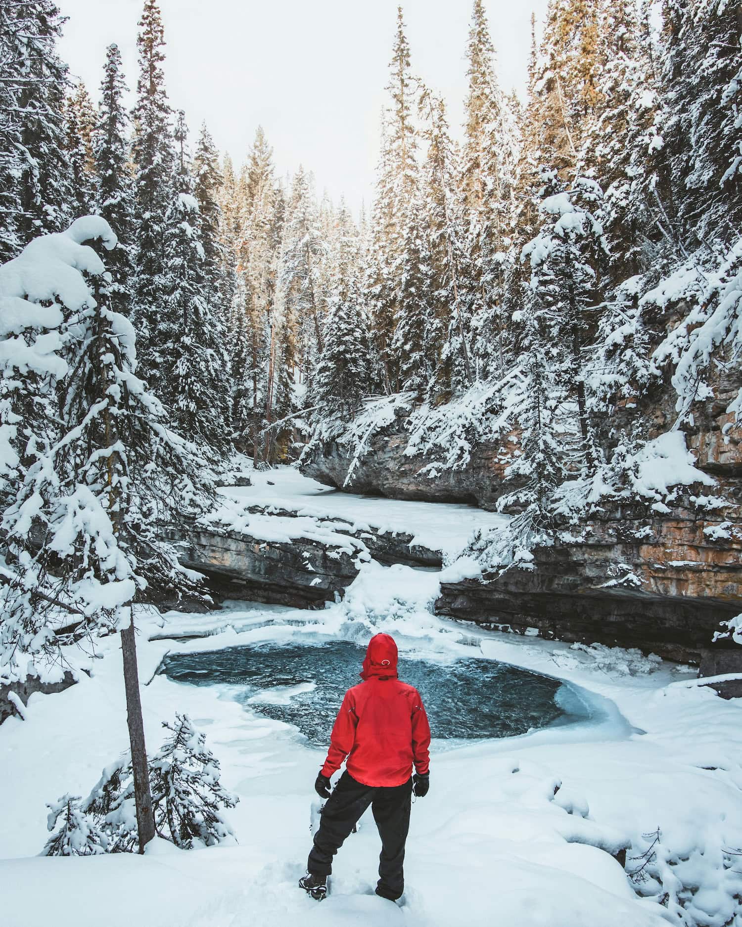 Mensch vor einem See im Winter im Johnston Canyon in Alberta