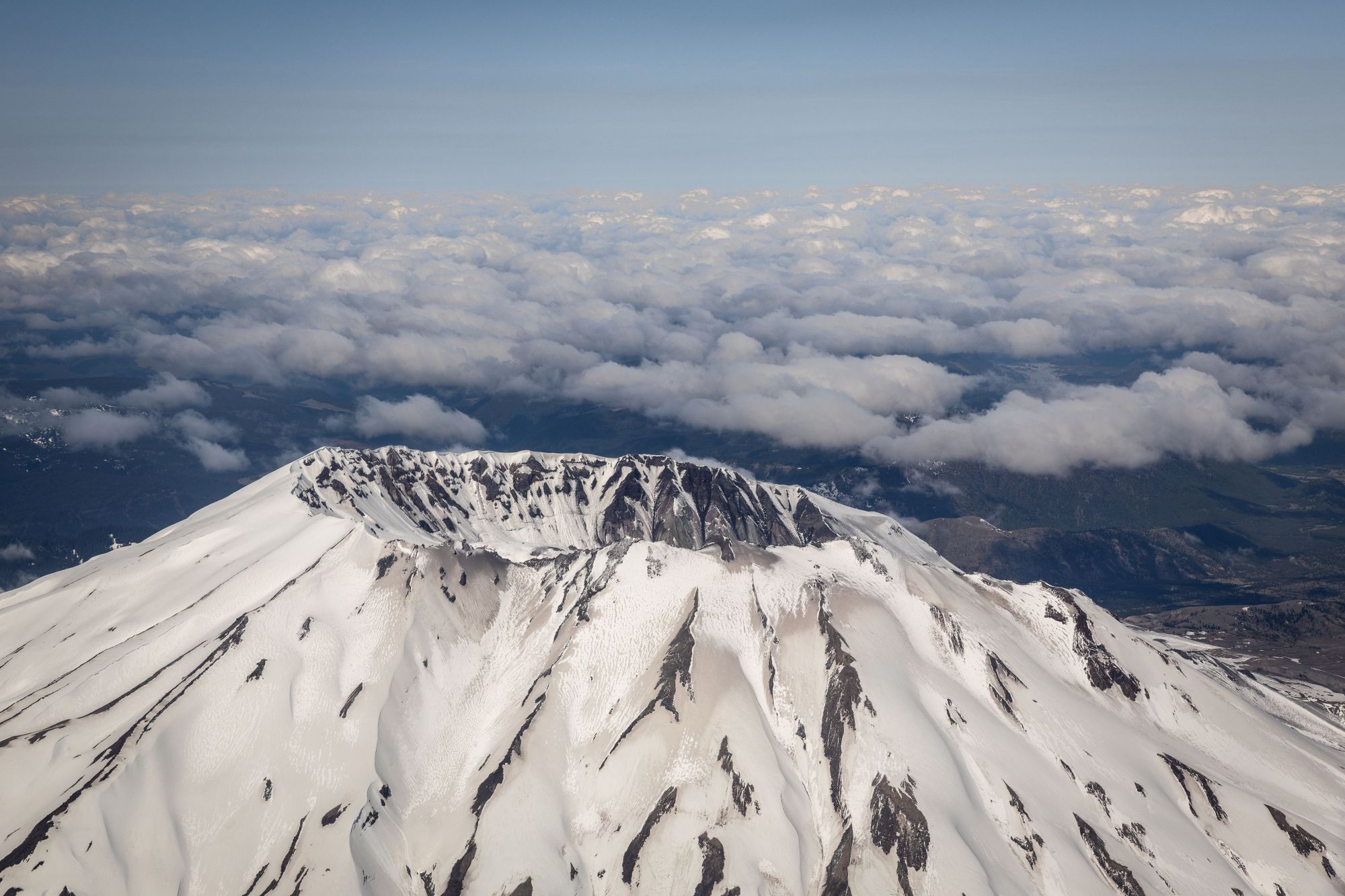 Luftaufnahme des schneebedeckten Mount St. Helens mit seinem gewaltigen, hufeisenförmigen Vulkankrater