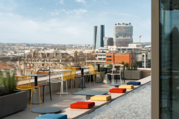 Dachterrasse des Ruby Lilou Marseille mit bunten Sitzmöbeln und Panoramablick über die Stadt.