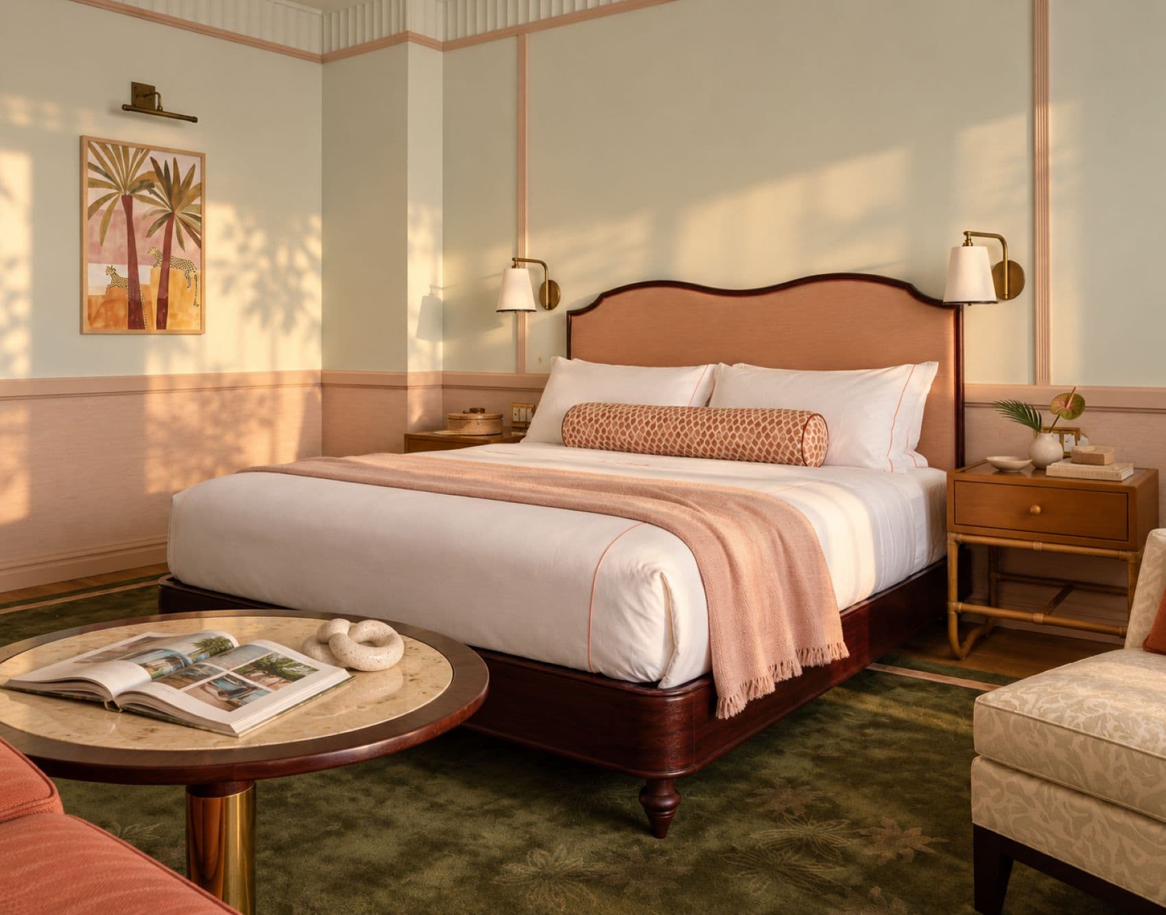 Gästezimmer im The Nora Hotel in West Palm Beach mit rosafarbenem Doppelbett, hellen Wandvertäfelungen, dunkelgrünem Teppich und tropischem Wandbild.