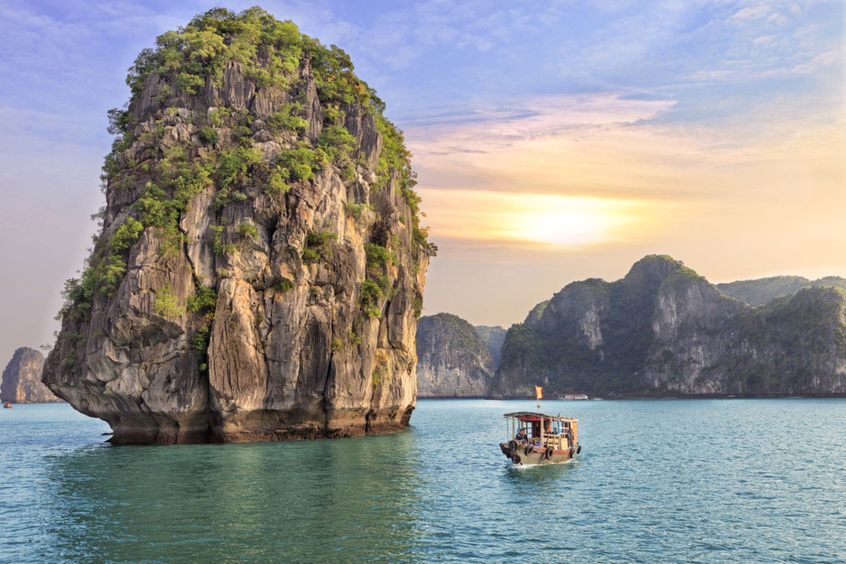 Boot zwischen mächtigen Kalksteinfelsen in der Halong-Bucht in Vietnam