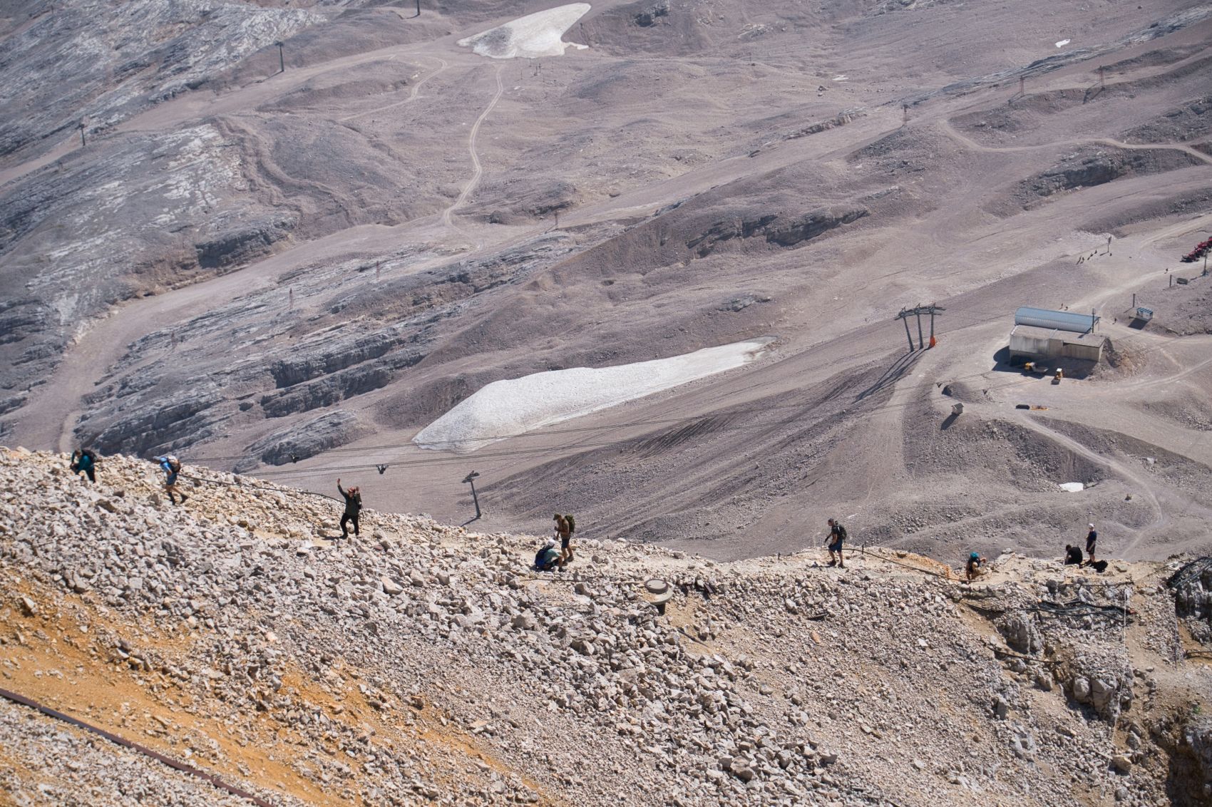 Wandergruppe auf einem steilen Felsrücken oberhalb des Zugspitzplatts.