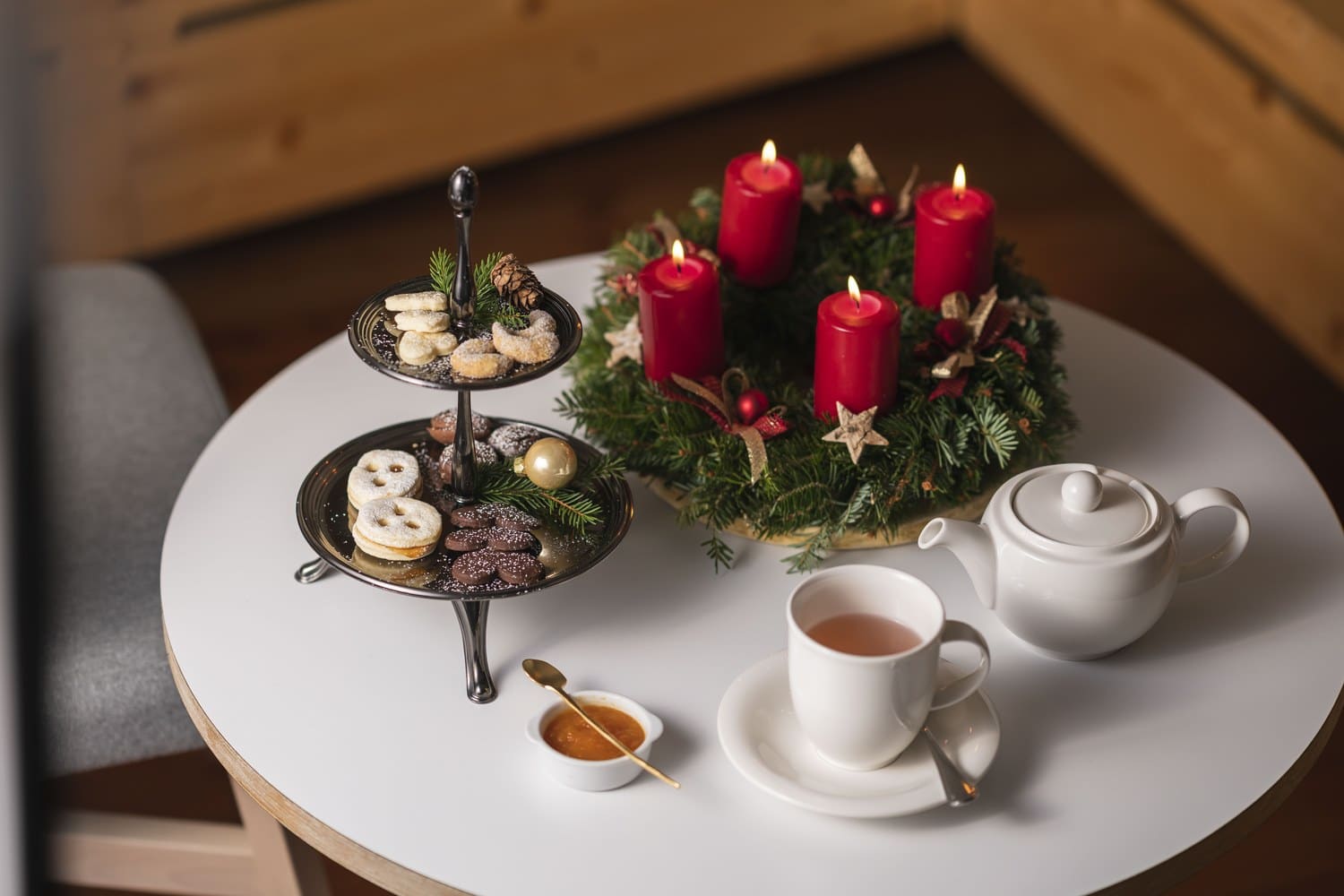 Adventskranz mit roten Kerzen, Tee und Gebäck auf einem Tisch im Hotel Gasthof Zum Hirschen