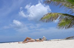 Frau im Bikini im Sand liegend auf Anguilla