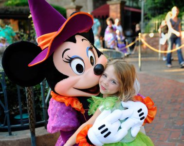 Ein Kind in den Armen von Mickey Mouse in einem der Freizeitparks in Orlando