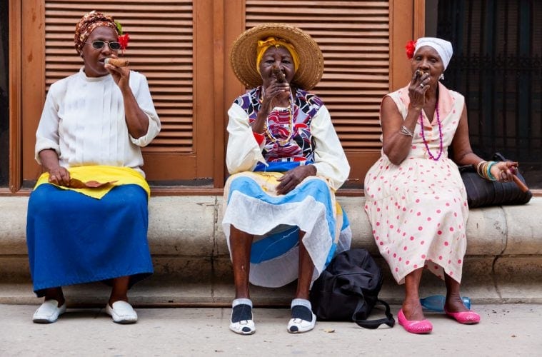 Drei Frauen sitzen auf einer Bank in Havanna